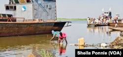 A boy and a woman wash intestines from a slaughterhouse in the Nile River, in Bor, Jonglei State, South Sudan.