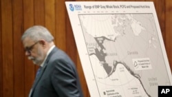 FILE - Federal Administrative Law Judge George Jordan steps past a display before a hearing in Seattle, to help determine whether a small American Indian tribe can once again hunt whales, Nov. 14, 2019. 