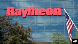 FILE - An American flag flies in front of the facade of Raytheon's Integrated Defense Systems facility in Woburn, Massachusetts, June 10, 2019. 