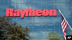 FILE - An American flag flies in front of the facade of Raytheon's Integrated Defense Systems facility in Woburn, Massachusetts, June 10, 2019. Three of the company's subsidiaries were announced on Jan. 2, 2025, as being among those sanctioned by China.