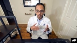 Medical director of Doctor on Demand Dr. Vibin Roy speaks to a patient during an online primary care visit from his home, April 23, 2021, in Keller, Texas.