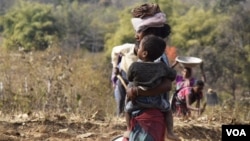With an unemployed alcoholic husband at home, this tribal woman in Jharkhand, like most others, looks after her child while being the sole breadwinner in the family. (Arti Munda for VOA)