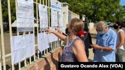 [Archivo] Una votante venezolana se busca en un listado en el centro de votación del colegio Lucila Palacios, Maracaibo, en las elecciones regionales del 21 de noviembre de 2021. La participación del CNE en la primaria es aún una incógnita.