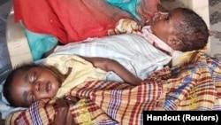 FILE - The twin babies of Sudanese refugee Fatma Ibrahim — who fled the violence in the city of Nyala, South Darfur — get treated for severe malnourishment at a Kalma IDP camp health center in South Darfur, Sudan, Feb. 18, 2024. 