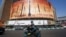 A man rides a motorbike past a billboard depicting Iranian ballistic missiles in service in Tehran on April 19, 2024. 