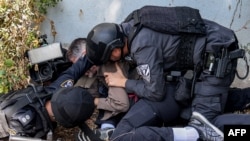 FILE — Israeli police and security forces assist a journalist taking cover during a rocket attack alert in Israel's southern city of Sderot near the border with Gaza, Oct. 12, 2023. At least 39 journalists have died while covering the Israel-Hamas war.