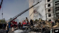 Following a Russian attack, first responders remove rubble at a residential building in Uman, central Ukraine, April 28, 2023. 