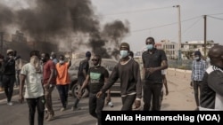 Protesters pushed parked cars onto streets to be used as roadblocks in Dakar, Senegal, March 16, 2023.