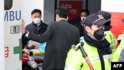 South Korean opposition party leader Lee Jae-myung, who was attacked in Busan, lies on a stretcher as he arrives at Seoul National University Hospital in Seoul on Jan. 2, 2024. 