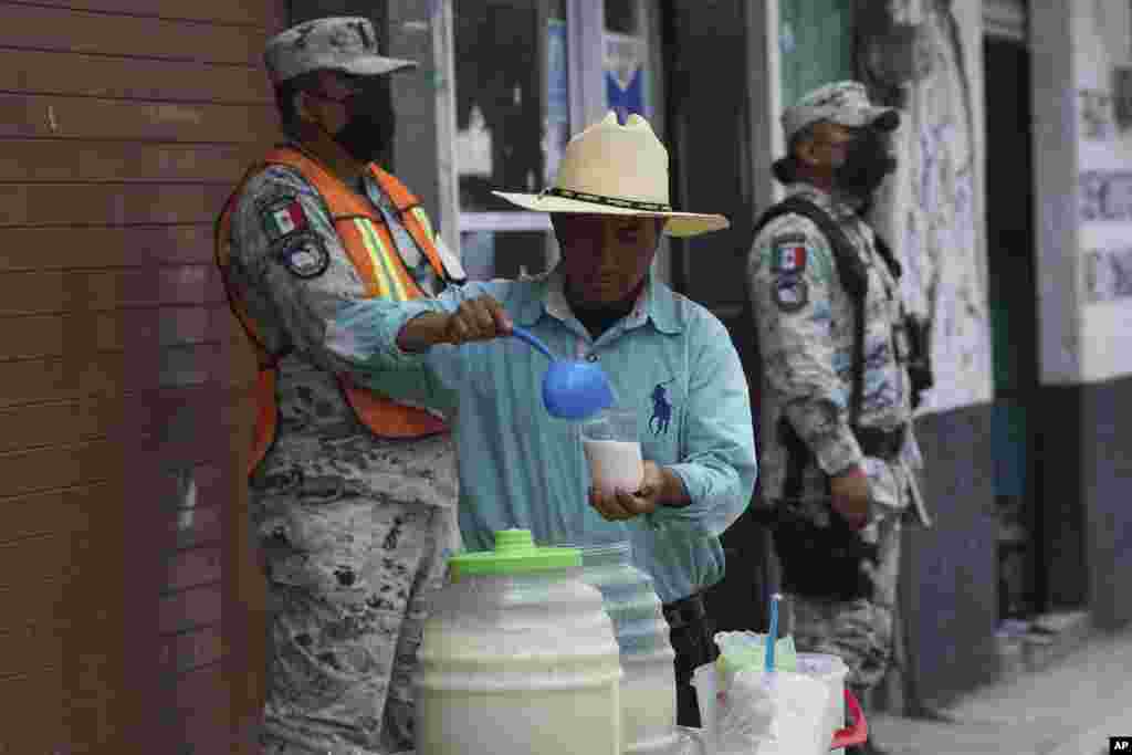 Un vendedor sirve bebidas mientras la ceniza del volcán Popocatépetl cubre las calles de Santiago Xalitzintla, México.&nbsp;Las autoridades le han estado diciendo a la gente que se mantenga fuera del radio de 12 kilómetros (7,5 millas) alrededor del pico.