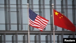 Bendera China dan AS berkibar di luar gedung perusahaan AS di Beijing, Ibu Kota China (Foto: ilustrasi). 