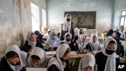 FILE - Afghan schoolgirls in class on the first day of the new school year in Kabul, March 25, 2023. 