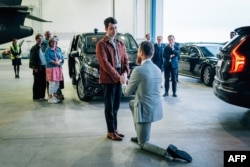 Johan Floderus (kanan), berlutut dan melamar pasangannya, setibanya di bandara Arlanda dekat Stockholm, Swedia, 15 Juni 2024, setelah dibebaskan dalam pertukaran tahanan dengan Iran. (Tom SAMUELSSON / Regeringskansliet / AFP)