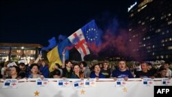 Demonstrators protesting Georgia's 'foreign influence' law attend a concert held to raise funds to pay police fines to secure the release of arrested fellow protesters, at Tbilisi's Republic Square on June 2, 2024.