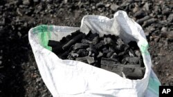 FILE - A sack of charcoal is filled in Gulu, Uganda, on May 27, 2023. Globally, around 2.3 billion people cook using solid biomass fuel – such as wood and charcoal – and kerosene.