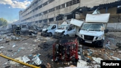 A firefighter works at a site of a branch of courier service Nova Poshta, hit by a Russian airstrike, amid Russia's attacks on Ukraine, in Kharkiv, northeastern Ukraine, June 30, 2024.