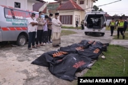 Para relawan melakukan salat jenazah terhadap sejumlah jasad pengungsi Rohingya penumpang kapal pengungsi yang terbalik, di Rumah Sakit Teuku Umar di Calang, Aceh Barat, pada 25 Maret 2024. (Foto: AFP/Zahlul AKBAR)