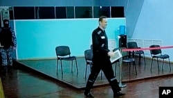 Russian opposition leader Alexei Navalny is seen on a TV screen as he appears in a video link provided by the Russian Federal Penitentiary Service during a hearing in Melekhovo, Russia, on Aug. 4, 2023.