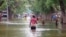 In this image made from video, residents move through floodwaters on a street in the town of Beledweyne, Somalia, Nov. 19, 2023. Officials say a cholera outbreak that started in Somalia in January is a consequence of the flooding in October and November.
