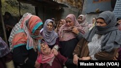 Family members of a former police officer mourn after he was shot dead in Baramulla district when he was offering morning prayers.