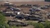 Cientos de tanques, vehículos blindados, camiones cisterna se pueden ver desde la carretera en la frontera sur de Israel. [Foto: Alejandro Ernesto, VOA]. 