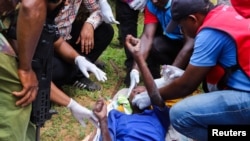 Members of the Kenya Red Cross and police officers attend to an emaciated member of a Christian cult named the Good News International Church in Shakahola forest of Kilifi county, Kenya, April 23, 2023.