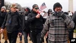 FILE - Joseph Biggs, right, and other Proud Boys members walk toward the U.S. Capitol in Washington, Jan. 6, 2021. 