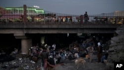 FILE - Afghans gather under a bridge to consume drugs, mostly heroin and methamphetamines in Kabul, Afghanistan, on Sept. 30, 2021. 
