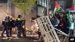 In this image from video, police move in to arrests dozens of activists as they break up a pro-Palestinian protest camp at the University of Amsterdam, in Amsterdam, Netherlands, May 7, 2024. (AP Photo/InterVision)