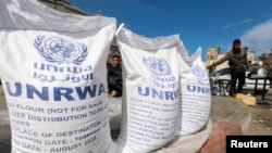 Pengungsi Palestina menunggu untuk menerima bantuan Badan Bantuan dan Pekerjaan PBB (UNRWA), di tengah konflik yang sedang berlangsung antara Israel dan kelompok Islam Palestina Hamas, di Rafah, di selatan Jalur Gaza, 7 Maret 2024. (Foto: REUTERS/Mohammed Salem )