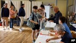 A woman casts her ballot in the second round of the legislative elections, in Rennes, western France, July 7, 2024.