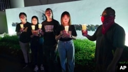 In this image taken and provided by Anti-Death Penalty Asia Network, members of Anti-Death Penalty Asia Network (ADPAN) hold candle outside Singapore Embassy in Kuala Lumpur, Malaysia, April 26, 2023.