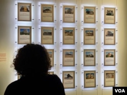 A visitor looks at a photo collection depicting destroyed homes of Palestinians during previous conflicts, at the exhibit "What Palestine Brings to the World" at the Arab World Institute in Paris, running through Nov. 19, 2023. (Lisa Bryant/VOA)