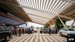 A handout photograph released by French Ministry for Europe and Foreign Affairs shows passengers queueing outside Diori Hamani international airport in Niamey, Niger, on Aug. 2, 2023.