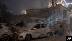 Cars and a building are seen after a rocket attack in Tel Aviv, Israel, Oct. 7, 2023.