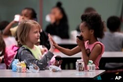 រូបឯកសារ៖ កូនសិស្សស្បែកសនិងសិស្សដើម​កំណើតអាហ្វ្រិក​លេងជាមួយ​គ្នា អំឡុងពេល​សម្រាក​បរិភោគអាហារ នៅ​សាលារៀនមួយ ក្នុងទីក្រុង Topeka រដ្ឋ Kansas កាលពីថ្ងៃទី១០ ខែឧសភា ឆ្នាំ២០២៤។