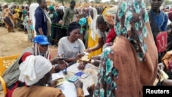 Sudanese refugees who have fled the violence in their country queue to receive food supplements from World Food Program near the border between Sudan and Chad in Adre, Chad, April 26, 2023.