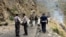 FILE - Security personnel inspect the site of a suicide attack near Besham city in the Shangla district of Khyber Pakhtunkhwa province, Pakistan, on March 26, 2024. 