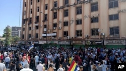 In this photo released by Suwayda24, people stage a protest in the southern city of Sweida, Syria, Aug 22, 2023. 