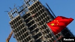 中国国旗在北京一处正在施工的楼盘前飘扬。（2013年11月4日）