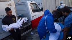 Palestinians mourn relatives killed in the Israeli bombardment of the Gaza Strip, in front of the morgue in Deir al Balah, Oct. 31, 2023. 