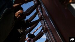 Neighbors raise a metal gate as they work to install it as a barricade against gangs, in the Petion-Ville neighborhood of Port-au-Prince, Haiti, April 20, 2024.