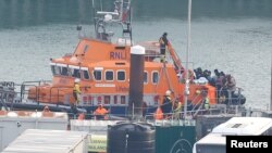 FILE - People believed to be migrants disembark a Royal National Lifeboat Institution lifeboat after being rescued from the English Channel while crossing from France, in Dover, Britain, Dec. 17, 2022. 