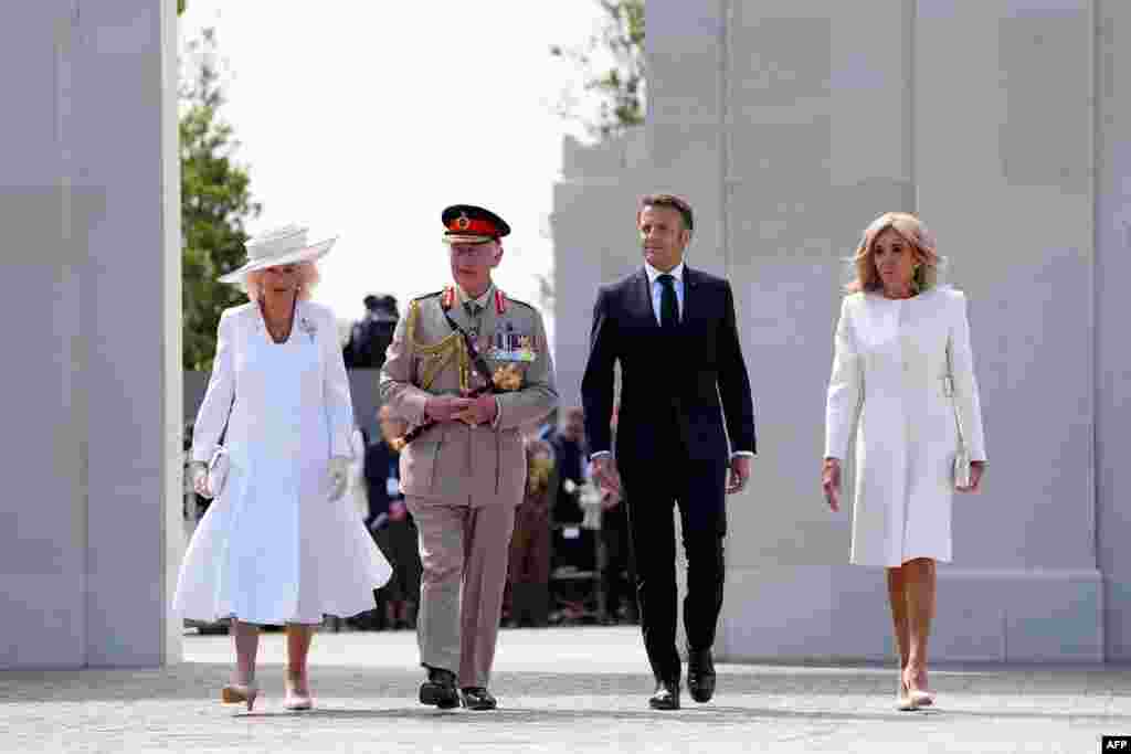 Britain's King Charles III (2L) and his wife Queen Camilla (L) walk with France's President Emmanuel Macron (2R) his wife Brigitte Macron pass the memorial wall during the UK Ministry of Defense and the Royal British Legion's commemorative ceremony marking the 80th anniversary of the World War II "D-Day" Allied landings in Normandy, at the World War II British Normandy Memorial near the village of Ver-sur-Mer in northwestern France, June 6, 2024.