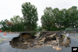 Train tracks on the Fitchburg Line extend over an area washed out by recent flooding, Wednesday, Sept. 13, 2023, in Leominster, Mass.