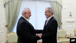 ইরানের প্রেসিডেন্টের দফতর থেকে সরবরাহ করা ছবিতে, ইরানের প্রেসিডেন্ট মাসুদ পেজেশকিয়ান (ডানে) হামাস নেতা ইসমাইল হানিয়েহ'র সাথে সাক্ষাৎ করছেন। ফটোঃ ৩০ জুলাই, ২০২৪।
