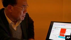 Zhang Yongzhen, the first scientist to publish a sequence of the COVID-19 virus, looks at a presentation on his laptop in a coffeeshop in Shanghai, Dec. 13, 2020.