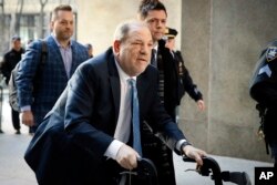 FILE - Harvey Weinstein arrives at a Manhattan courthouse as jury deliberations continue in his rape trial in New York, Feb. 24, 2020.