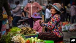 រូបឯកសារ៖ ស្ត្រីម្នាក់កំពុងលក់បន្លែនៅក្នុងផ្សារមួយ នៅរាជធានីភ្នំពេញ កាលពីថ្ងៃទី ១០ ខែវិច្ឆិកា ឆ្នាំ ២០២២។ 