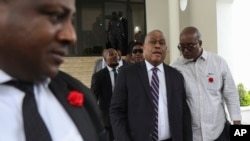 FILE - Garry Conille, second-right, leaves his swearing-in ceremony as prime minister in Port-au-Prince, Haiti, June 3, 2024. 